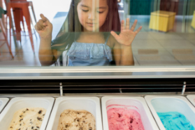 little girl looking into a case of ice cream flavors at an ice cream shop